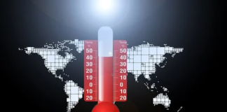 foto a colori di un mappamondo con, al centro, un termometro che segna le elevate temperature atmosferiche di colore rosso