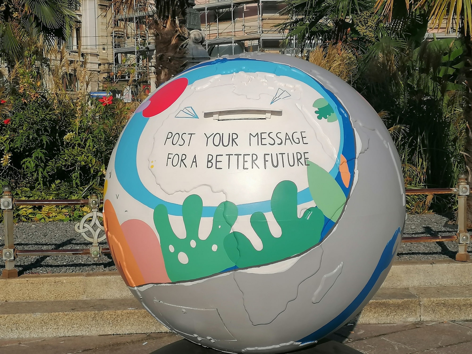 su un oggetto dalla forma tonda leggiamo la scritta "post your message for a better future". Sopra la scritta si apre una fenditura