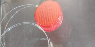 la foto a colori mostra un ciondolo a forma di cerchio di colore rosso
