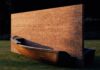 L'ideologia. L'immagine mostra un'opera d'arte del 1979 dell'artista Fabio Mauri chiamata "Muro d'Europa": una barca di legno divisa a metà da un muro di mattoni su un prato sintetico.