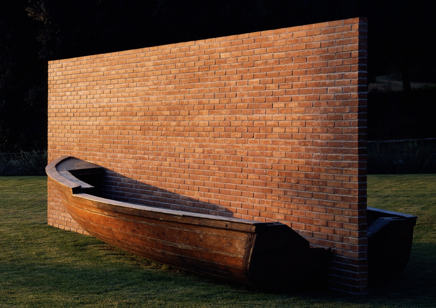 L'ideologia. L'immagine mostra un'opera d'arte del 1979 dell'artista Fabio Mauri chiamata "Muro d'Europa": una barca di legno divisa a metà da un muro di mattoni su un prato sintetico.